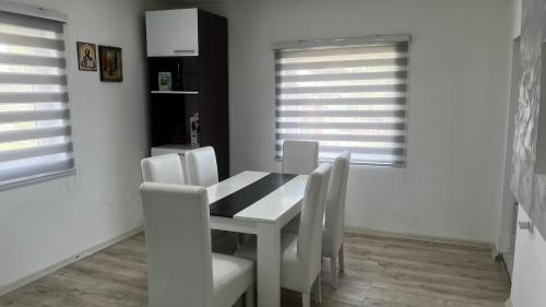 a dining room with a white table and white chairs at Čajića avlija in Obrenovac