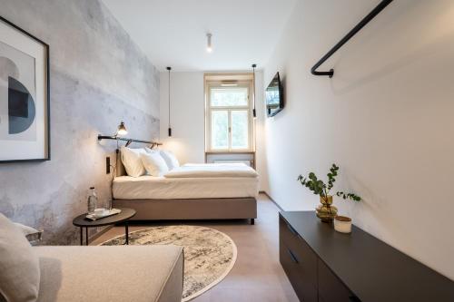 a bedroom with two beds and a table in a room at HONEST Karlin in Prague