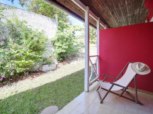 a chair and a hat sitting on a patio at Résidence Ti'Kéol - Appartements avec terrasse 2 à 4 personnes, piscine in Sainte-Anne