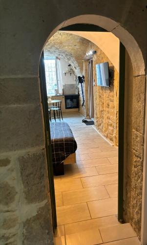 une arche menant à une pièce avec un lit et une cuisine dans l'établissement Studio Montfrin, à Montfrin