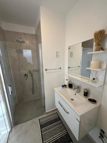 ein weißes Badezimmer mit Dusche und Waschbecken in der Unterkunft Студия в комплексе Thalassa с видом на горы in Elea