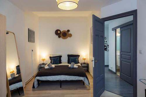 - une chambre avec un grand lit et une porte bleue dans l'établissement OIQIA • Escale, à Blois