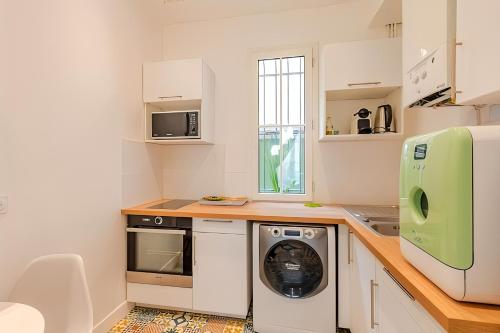 une cuisine avec un lave-linge et un sèche-linge sur un comptoir dans l'établissement Loft à 2 pas des Champs Elysées et de la Défense!, à Neuilly-sur-Seine