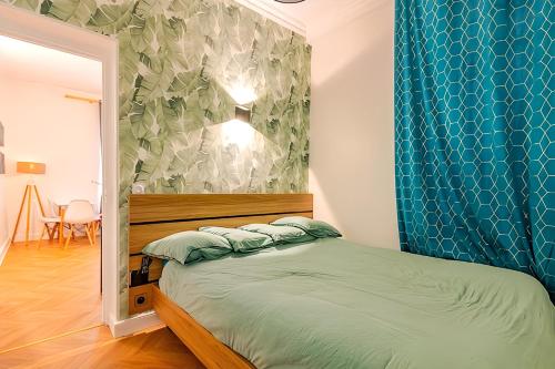 une chambre avec un lit avec un mur bleu dans l'établissement Loft à 2 pas des Champs Elysées et de la Défense!, à Neuilly-sur-Seine