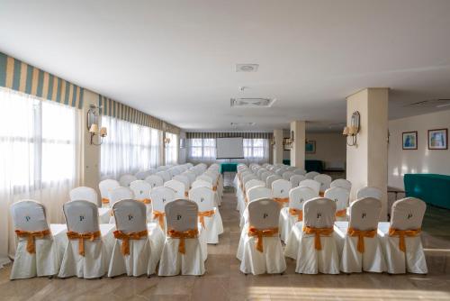 a room with rows of white chairs in a room at Parador de Melilla in Melilla
