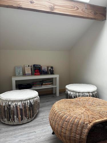 a room with two stools and a table with books at La Piconette in Ciney
