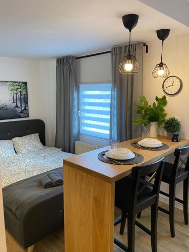 a bedroom with a bed and a table with chairs at Domki na skraju lasu in Jasień