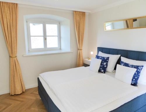 a bedroom with a large bed and a window at Jagdschloß zu Hohen Niendorf Fewo 1 ELEONORE in Hohen Niendorf