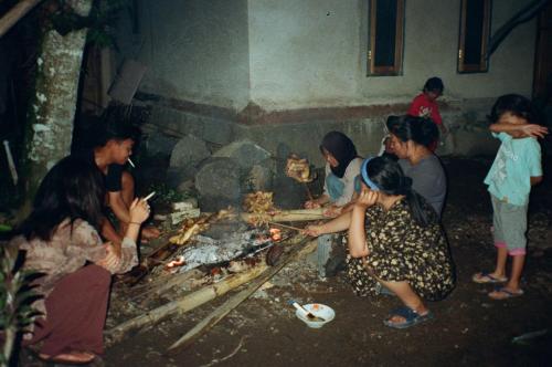 a group of people cooking food over a fire at Aulia Bungalows in Tetebatu