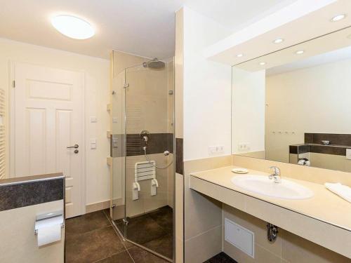 a bathroom with a sink and a shower with a mirror at Jagdschloß zu Hohen Niendorf Fewo 21 in Hohen Niendorf