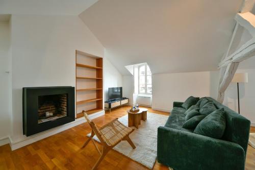 - un salon avec un canapé vert et une cheminée dans l'établissement OIQIA • Allegra, à Issoudun