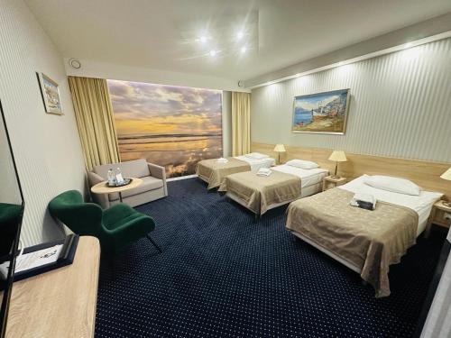 a hotel room with two beds and a couch at Miejsca noclegowe w Arka Medical SPA in Kołobrzeg