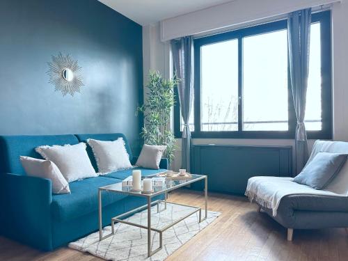 salon z niebieską kanapą i stołem w obiekcie Stylish Apartment with a Balcony in Paris w Paryżu