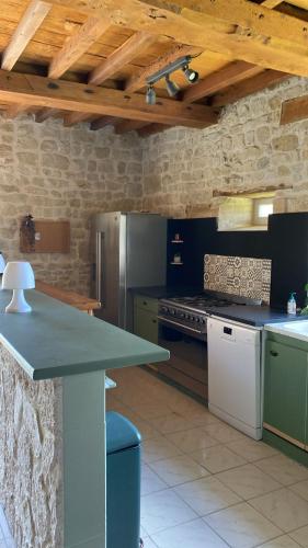 - une cuisine avec un comptoir et une cuisinière four supérieur dans l'établissement Maison en pleine nature proche plage Omaha Beach!, à Mandeville-en-Bessin