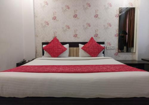 a bedroom with a large bed with red pillows at Hotel Galaxy in Indore