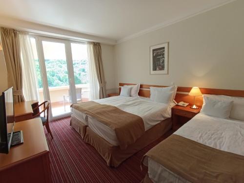 a hotel room with two beds and a window at Hotel Metropol – Metropol Lake Resort in Ohrid