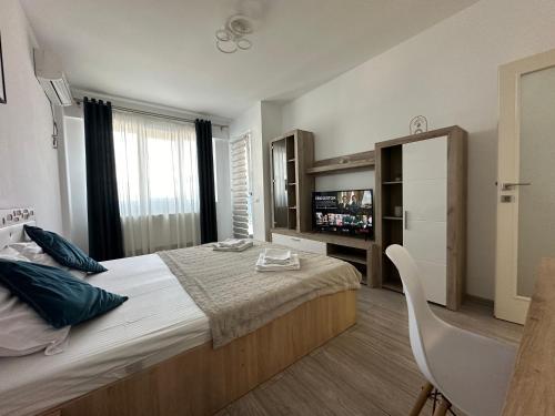 a bedroom with a large bed and a refrigerator at RS Q Studio in Iaşi