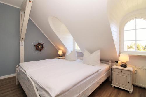 a bedroom with a white bed with an attic at Ostseeresidenz Appartements Wischuer Fewo 37 in Wischuer