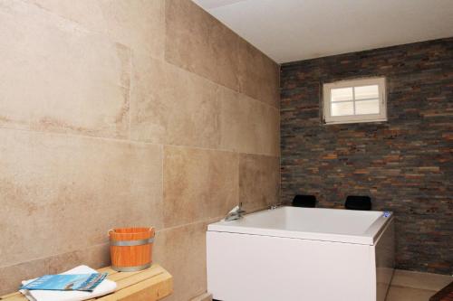 a bathroom with a white tub and a brick wall at Ostseeresidenz Appartements Wischuer Fewo 36 in Wischuer
