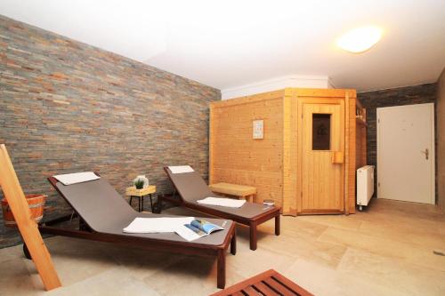 a room with two chairs and a brick wall at Ostseeresidenz Appartements Wischuer Fewo 36 in Wischuer