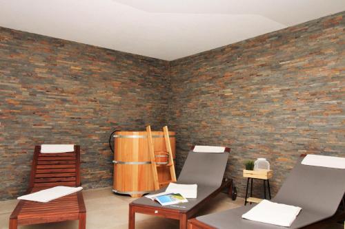 a room with chairs and a brick wall at Ostseeresidenz Appartements Wischuer Fewo 36 in Wischuer