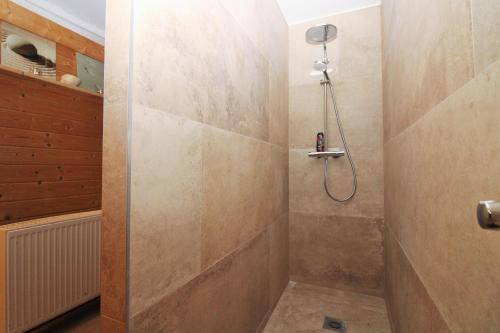 a bathroom with a shower with a stone wall at Ostseeresidenz Appartements Wischuer Fewo 26 in Wischuer
