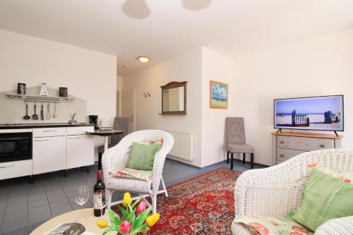 a living room with two chairs and a kitchen at Ostseeresidenz Appartements Wischuer Fewo 22 in Wischuer