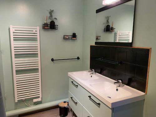 a bathroom with a sink and a mirror at Maison en pleine nature proche plage Omaha Beach! in Mandeville-en-Bessin