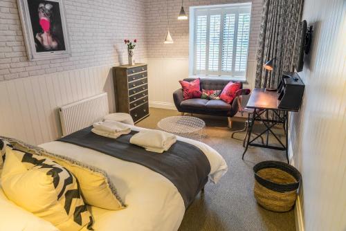 a bedroom with a bed and a chair in a room at Timbrell's Yard in Bradford on Avon