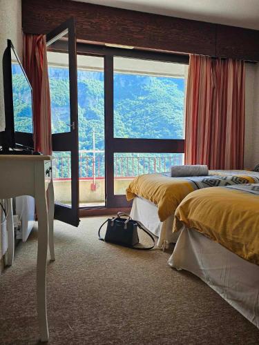 une chambre avec deux lits et une grande fenêtre dans l'établissement La Bicyclette Chambre Privée , Le Refuge Du Phoenix, à Échevis