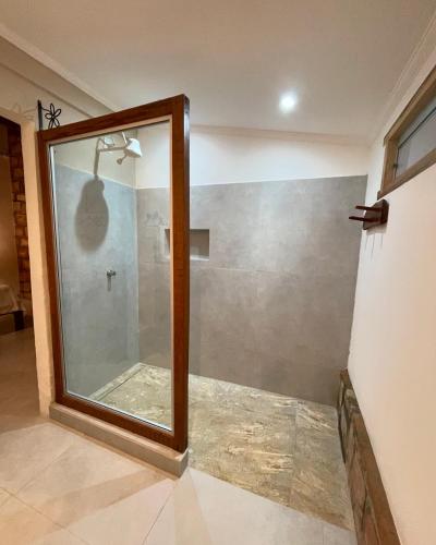a shower with a glass door in a bathroom at Hospedagem do Sítio in Lençóis