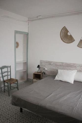 a bedroom with a bed and a chair and a mirror at El Terrer 1834 Apartament in Santpedor