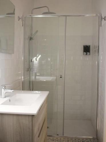 a bathroom with a glass shower and a sink at El Terrer 1834 Apartament in Santpedor