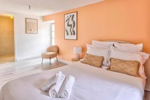 une chambre avec un grand lit blanc avec des serviettes dessus dans l'établissement OIQIA • Hesperis, à Sarlat-la-Canéda