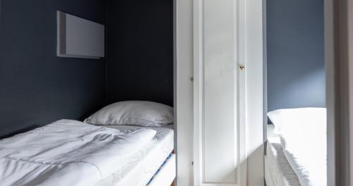 a small bedroom with a bed and a mirror at Heerlijk bos chalet met ongekende rust en vrijheid in Nunspeet