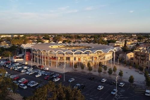 Una vista aérea de un edificio con estacionamiento. en Au cœur des Caladons, en Lunel