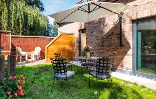 a patio with a table and chairs and an umbrella at Amazing Home In Knesselare With Sauna in Knesselare