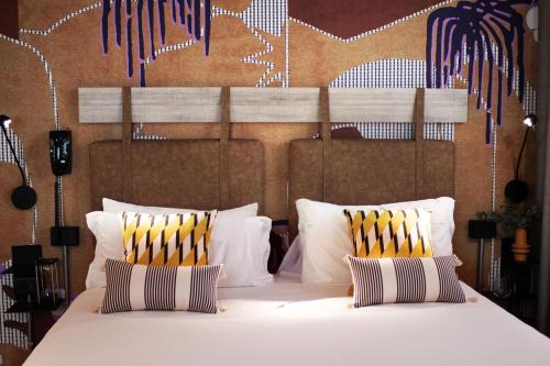 a bedroom with a large white bed with two pillows at Mercure Roma Cinecittà in Rome