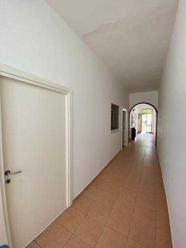 an empty hallway with a door and a tile floor at Zanella Bed in Torre Lapillo