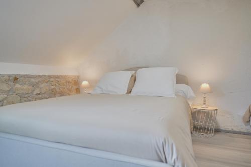 une chambre avec un lit blanc avec deux oreillers dans l'établissement Le Grand Prateau - à 800m du Zoo, à Saint-Aignan