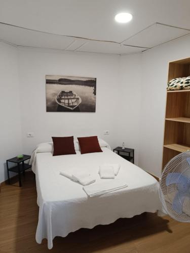 a bedroom with a white bed and a fan at Pilgrim Rooms in Redondela