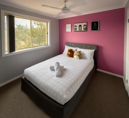 a bedroom with two teddy bears sitting on a bed at Prestons Dream Holiday 4 Bedroom in Prestons