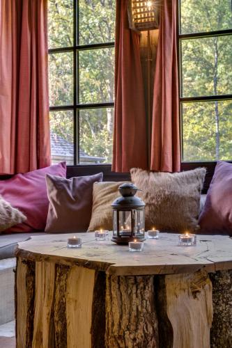 a living room with a tree stump table with candles on it at Les Cabanes de Rensiwez in Mabompré