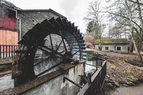 an old watermill in the middle of a river at Les Cabanes de Rensiwez in Mabompré