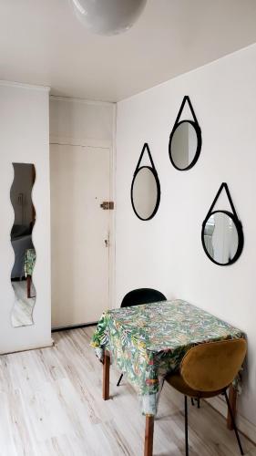 une salle à manger avec une table et des miroirs sur le mur dans l'établissement Cosy Studio près du Vieux Port de La Rochelle, à La Rochelle