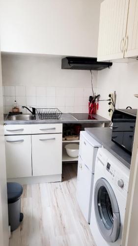 - une cuisine blanche avec un lave-linge et un évier dans l'établissement Cosy Studio près du Vieux Port de La Rochelle, à La Rochelle