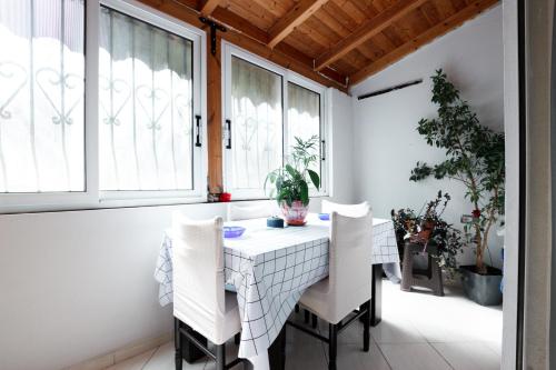 una sala da pranzo con tavolo e sedie bianchi di City Side a Gjirokastër