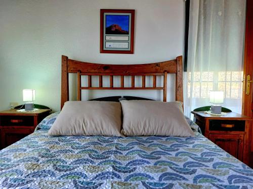 a bedroom with a bed with two nightstands and two lamps at Simón in Barlovento