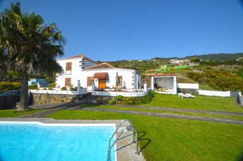 a villa with a swimming pool and a house at Simón in Barlovento