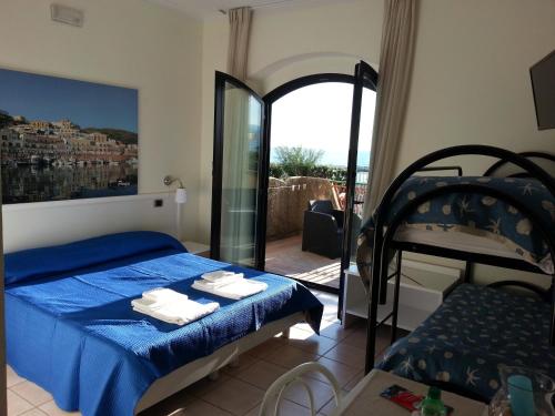 a bedroom with a blue bed and a balcony at Hotel Tirreno Formia in Formia